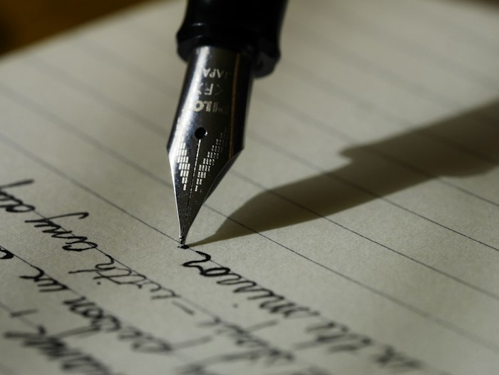 A pen resting on handwritten notes